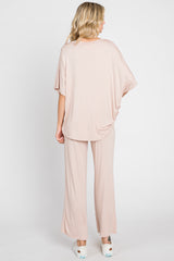 woman wearing a light pink oversized top and matching wide-leg pants, viewed from the back