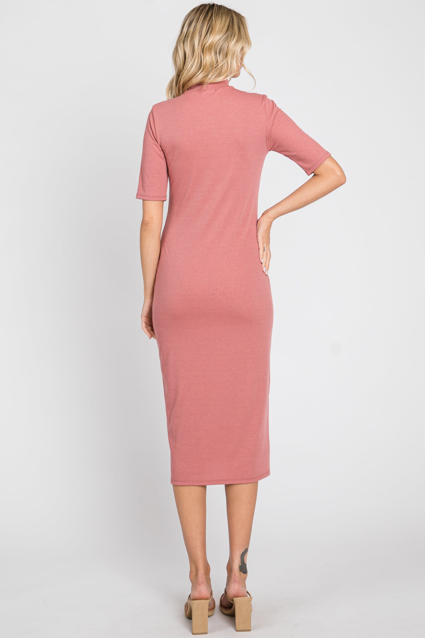 back view of woman wearing a mauve ribbed short sleeve midi dress with a mock neck