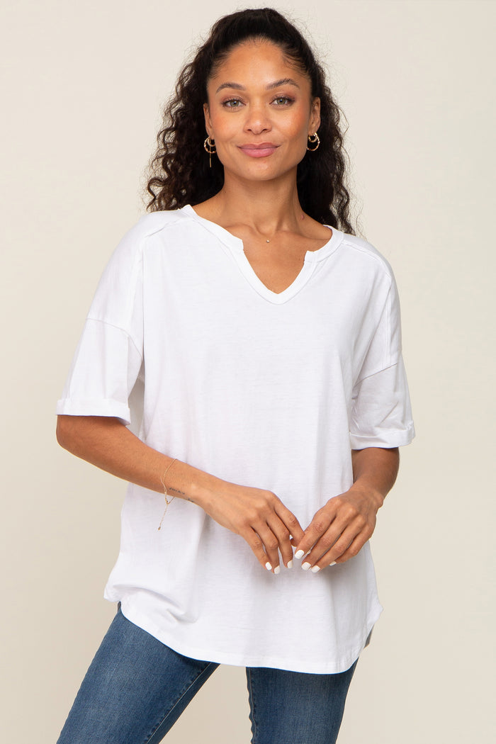 woman wearing a white relaxed fit v-neck t-shirt with short sleeves and a slight high-low hem, paired with blue jeans