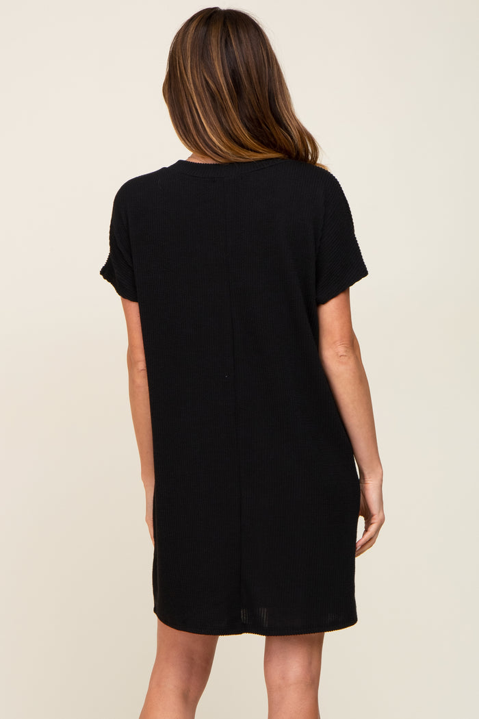 woman wearing a short sleeve black casual dress, view from the back