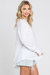 woman wearing a white long sleeve shirt paired with light blue distressed denim shorts