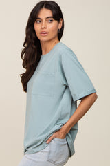 woman wearing a light blue short sleeve top with a chest pocket and relaxed fit