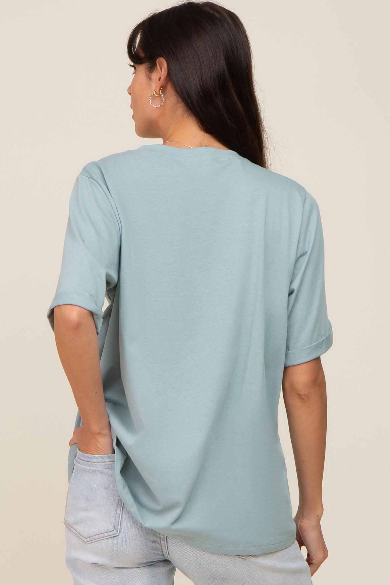 back view of a woman wearing a light blue oversized t-shirt and light wash denim jeans