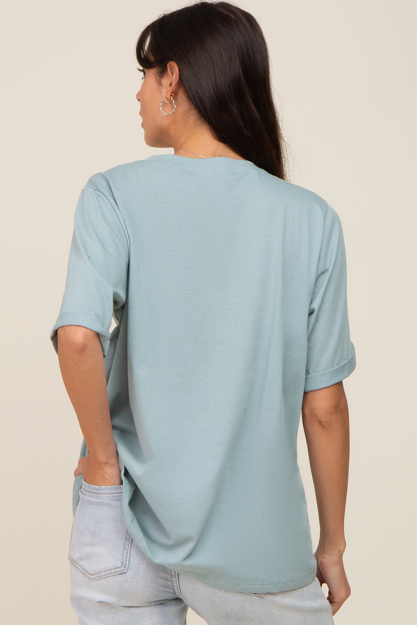 back view of a woman wearing a light blue oversized t-shirt and light wash denim jeans