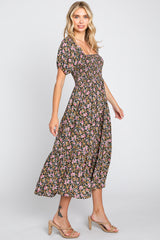 woman wearing a black floral midi dress with puff sleeves and a fitted bodice, posing sideways