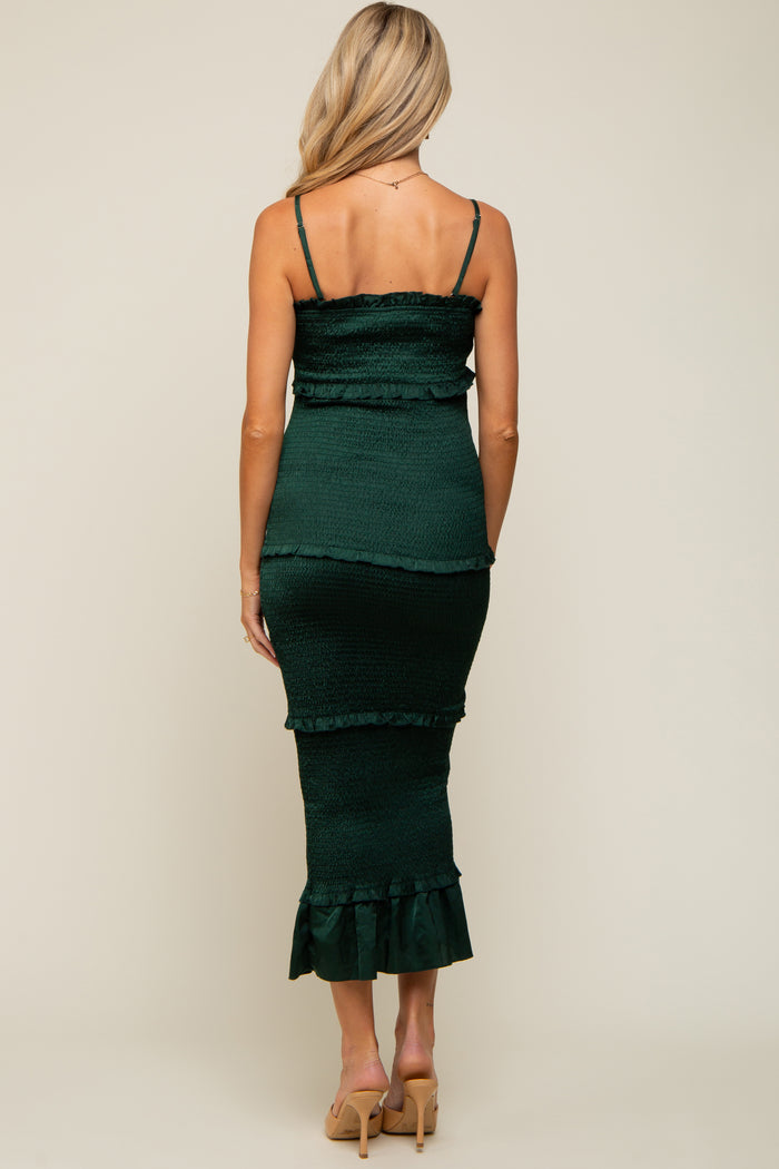 woman wearing a dark green maternity dress with ruffle details and a fitted silhouette, showing a baby bump from the back