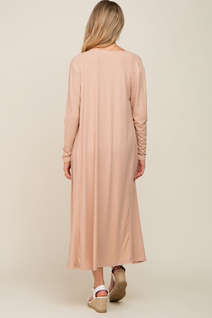 woman wearing a long blush pink maternity maxi dress with long sleeves seen from the back