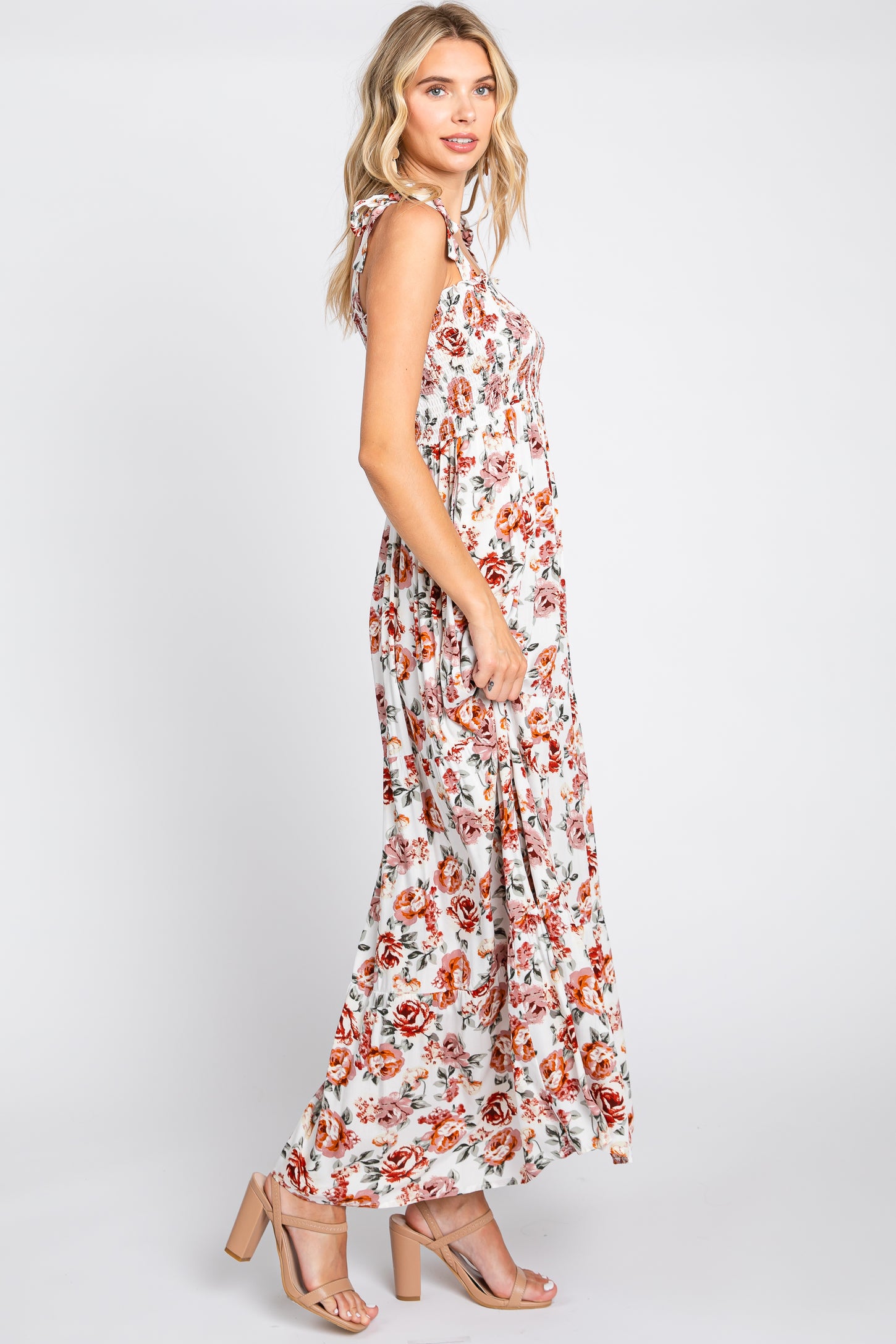 woman wearing a white floral maxi dress with a flowy silhouette and adjustable straps