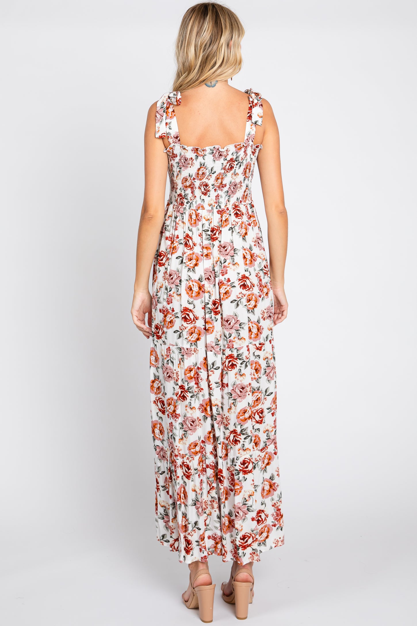 woman wearing a floral maxi dress with ruffle straps and a smocked back, shown from the back