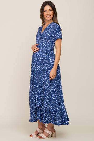 smiling pregnant woman wearing a blue floral short sleeve maternity wrap maxi dress with beige heels