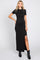 woman wearing a black short sleeve maxi dress with a side slit and styled with black ankle boots