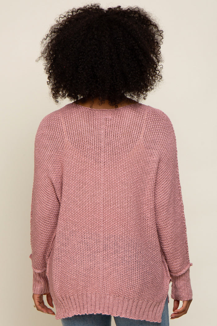 woman wearing a light pink oversized knit sweater with a relaxed fit and drop shoulders, viewed from the back