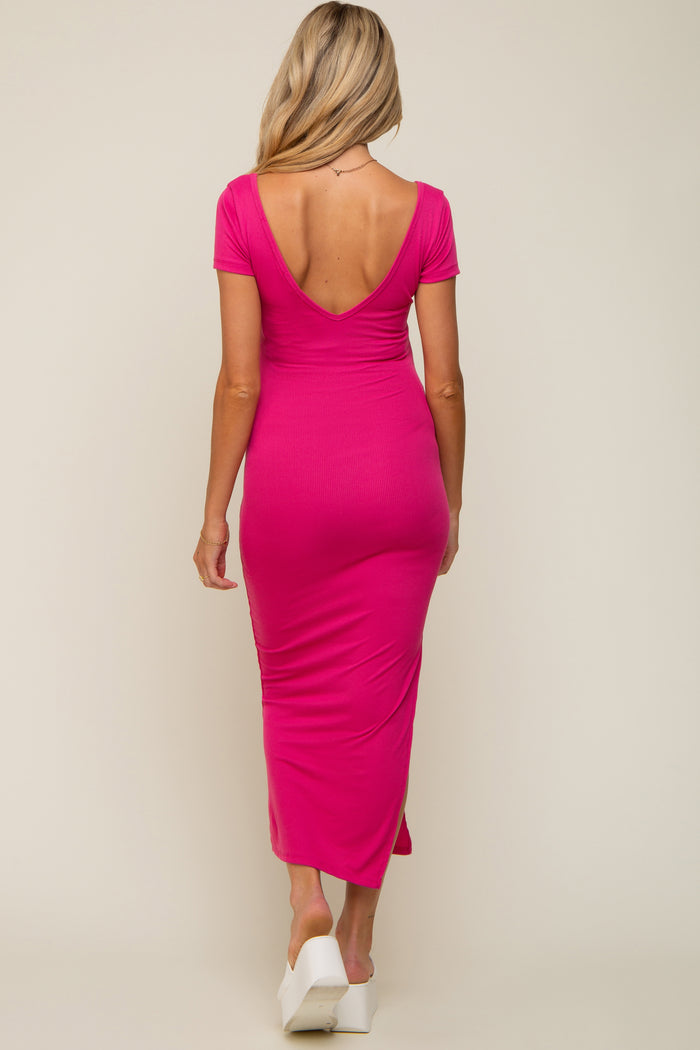 woman wearing a pink maternity dress with a deep V-back and short sleeves, showcasing a baby bump