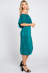 woman wearing a teal off-the-shoulder midi dress with ruffle sleeves and a pleated design, standing sideways