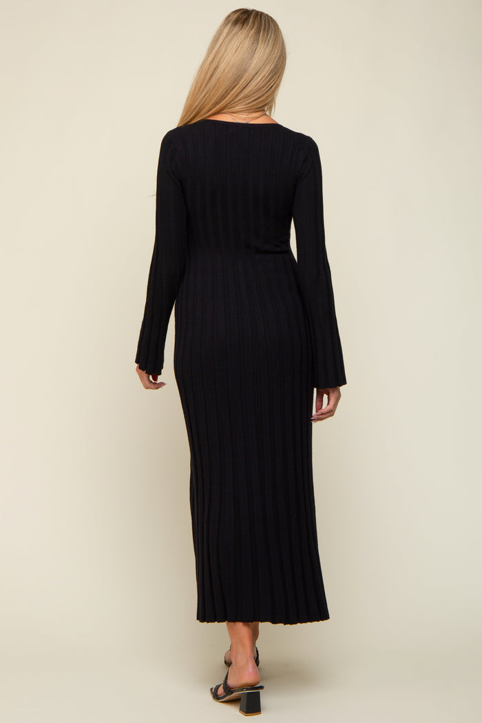 woman wearing a black ribbed maternity dress with long sleeves and a flared hem, showing a baby bump from the back