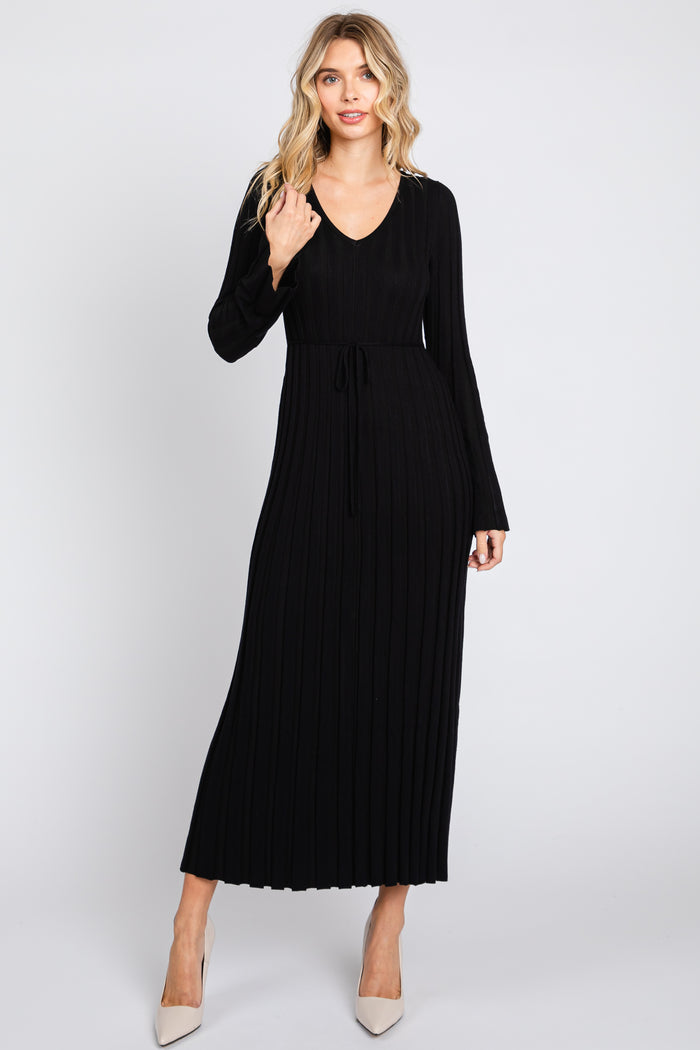 woman wearing a black ribbed maxi dress with long sleeves and a tied waist detail