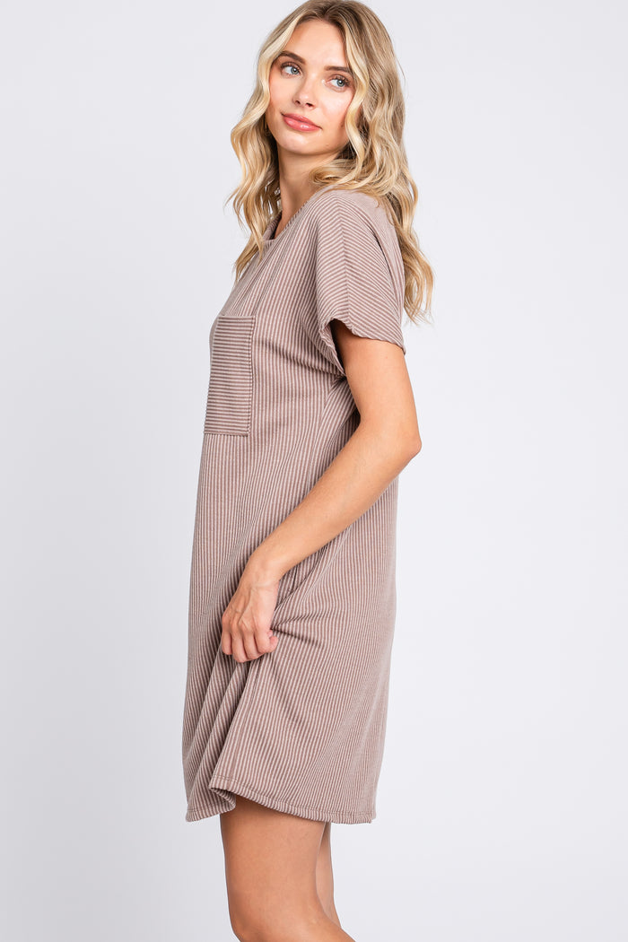woman wearing a taupe short sleeve ribbed dress with a chest pocket, standing sideways