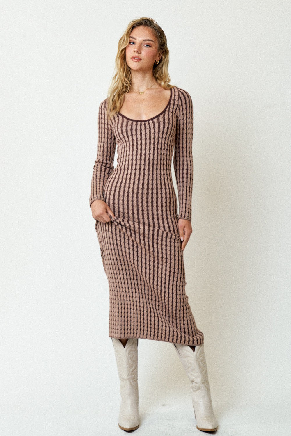 woman wearing a long sleeve ribbed midi dress in brown and beige stripes with knee-high white boots