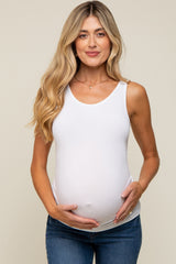 woman wearing a white maternity tank top and holding her baby bump
