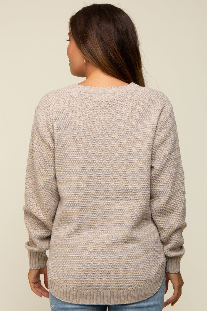 woman wearing a beige maternity sweater with a textured knit and relaxed fit, shown from the back