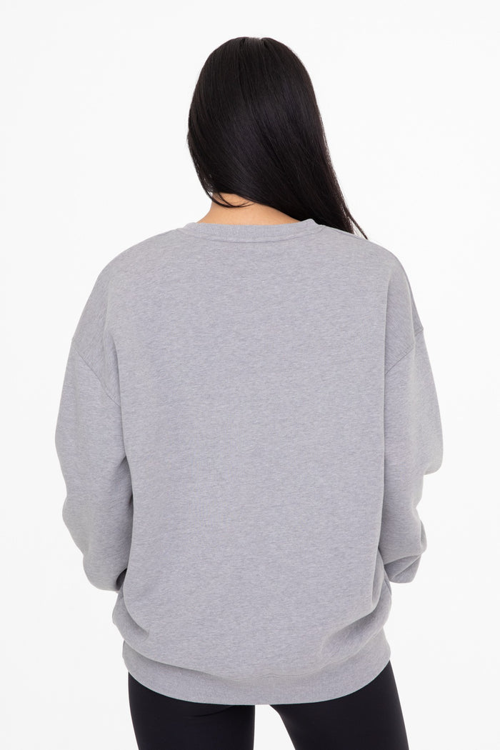 woman wearing a gray oversized sweatshirt from the back with long sleeves and a relaxed fit