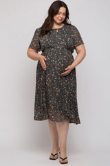 woman wearing a dark floral short sleeve maternity dress and holding her baby bump