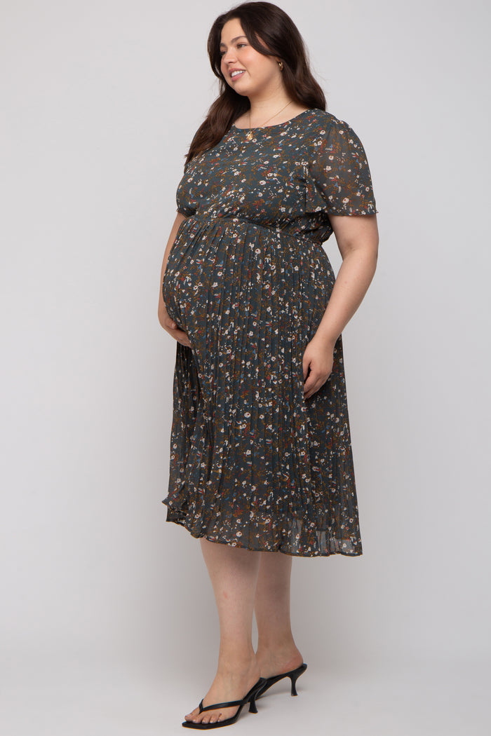 woman wearing a floral patterned maternity plus dress with short sleeves and a flowing skirt, showing her baby bump