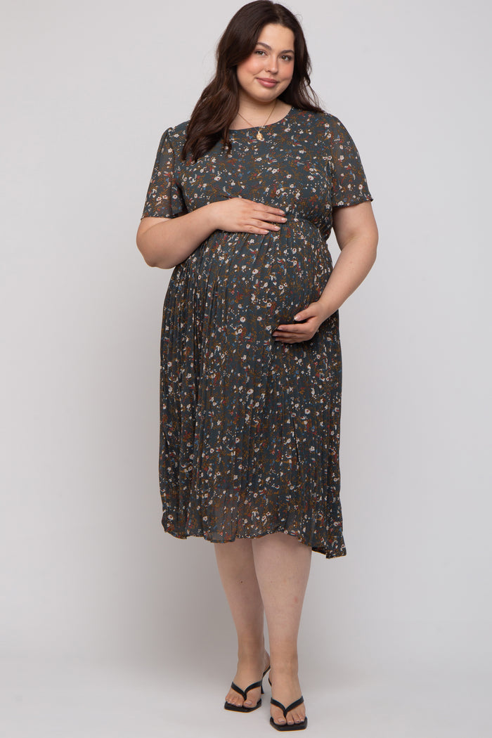 woman wearing a floral pattern short sleeve maternity dress and gently holding her baby bump