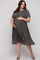 woman wearing a dark floral print maternity plus dress and holding her baby bump
