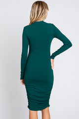 woman wearing a green long sleeve ribbed midi dress with ruching details at the back