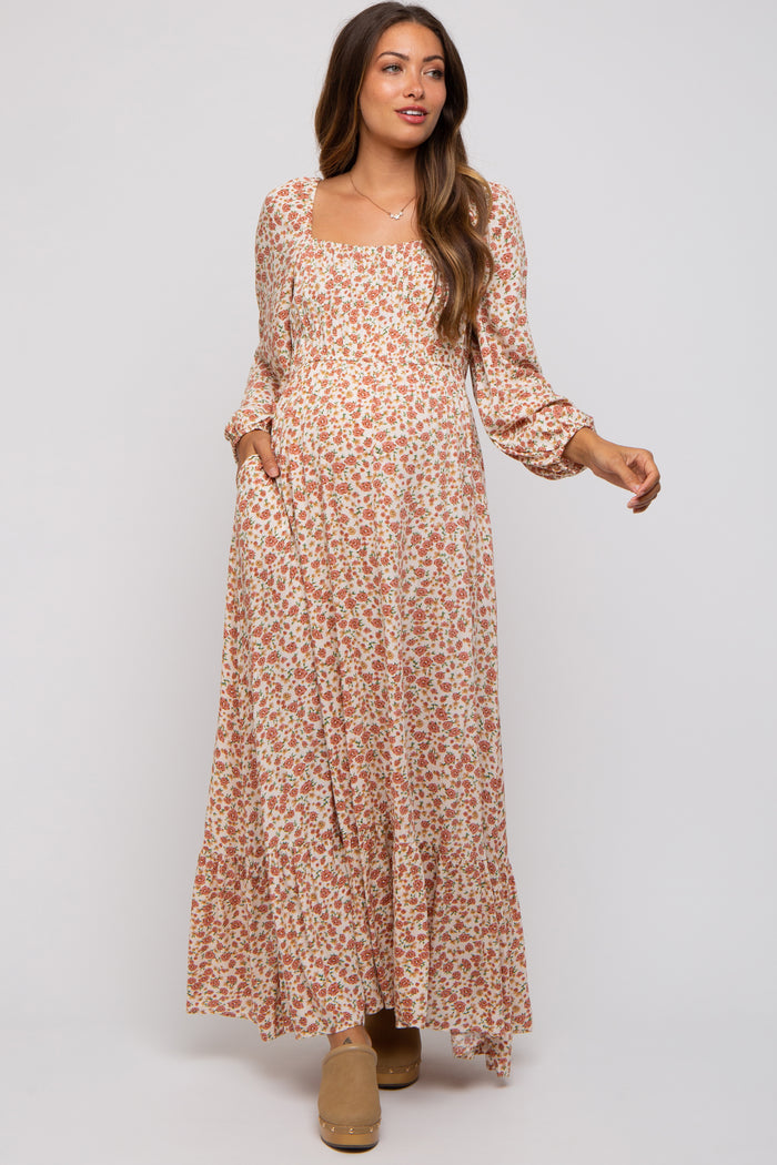 woman wearing a floral long sleeve maternity maxi dress with pockets and a visible baby bump