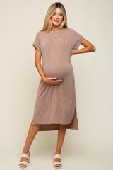 woman wearing a taupe ribbed maternity dress with short sleeves and a side slit, holding her baby bump