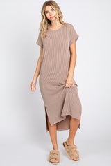 woman wearing a brown striped short sleeve maxi dress with side slits and tan fuzzy slippers