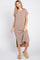 woman wearing a brown striped short sleeve maxi dress with side slits and tan fuzzy slippers