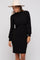 woman wearing a black ribbed long sleeve dress with a mock neck and puffed sleeves, accessorized with a wide-brim hat