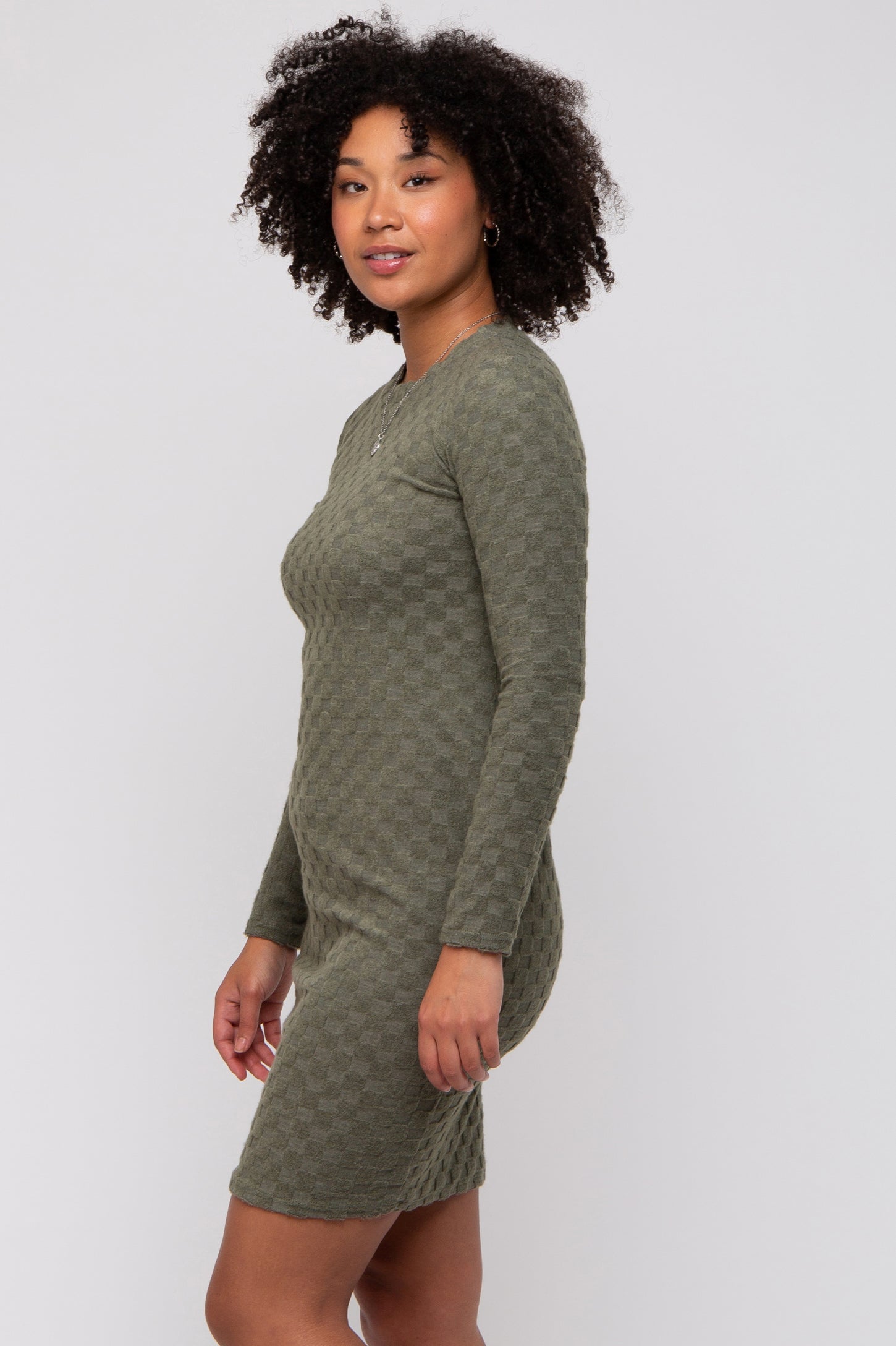 woman wearing a long sleeve olive green textured bodycon dress with a fitted silhouette