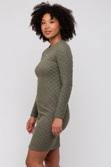 woman wearing a long sleeve olive green textured bodycon dress with a fitted silhouette