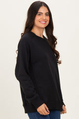 woman wearing a black long sleeve sweatshirt with ribbed details and a relaxed fit