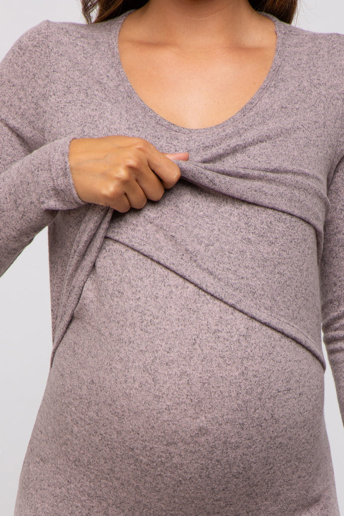 woman wearing a mauve long sleeve maternity top with a ruching detail and holding her baby bump