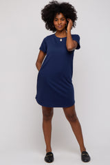 woman wearing a navy blue short sleeve dress with a relaxed fit and pockets, standing confidently