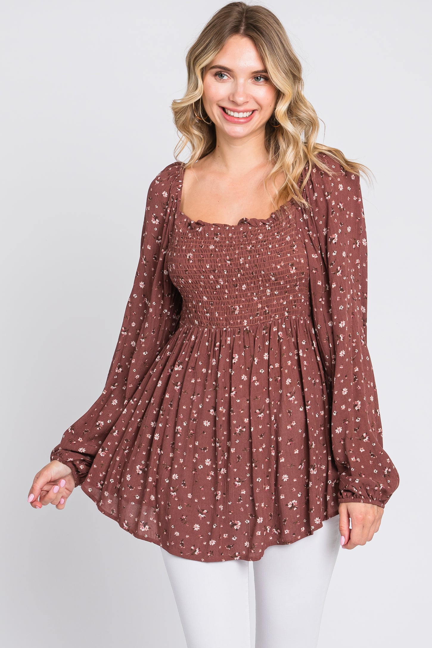 woman wearing a brown floral smocked blouse with long sleeves and a square neckline