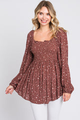 woman wearing a brown floral smocked blouse with long sleeves and a square neckline