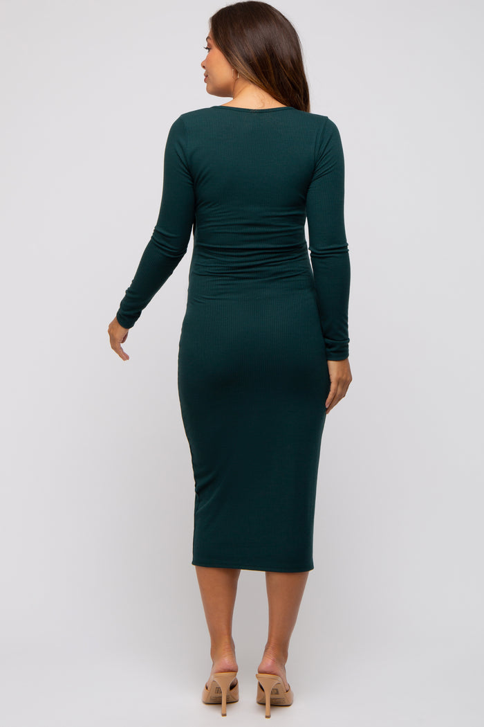 woman wearing a dark green long sleeve maternity dress with a fitted silhouette and ruched detailing on the back
