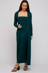woman wearing a dark green ribbed maxi dress with a long open cardigan and strappy black heels
