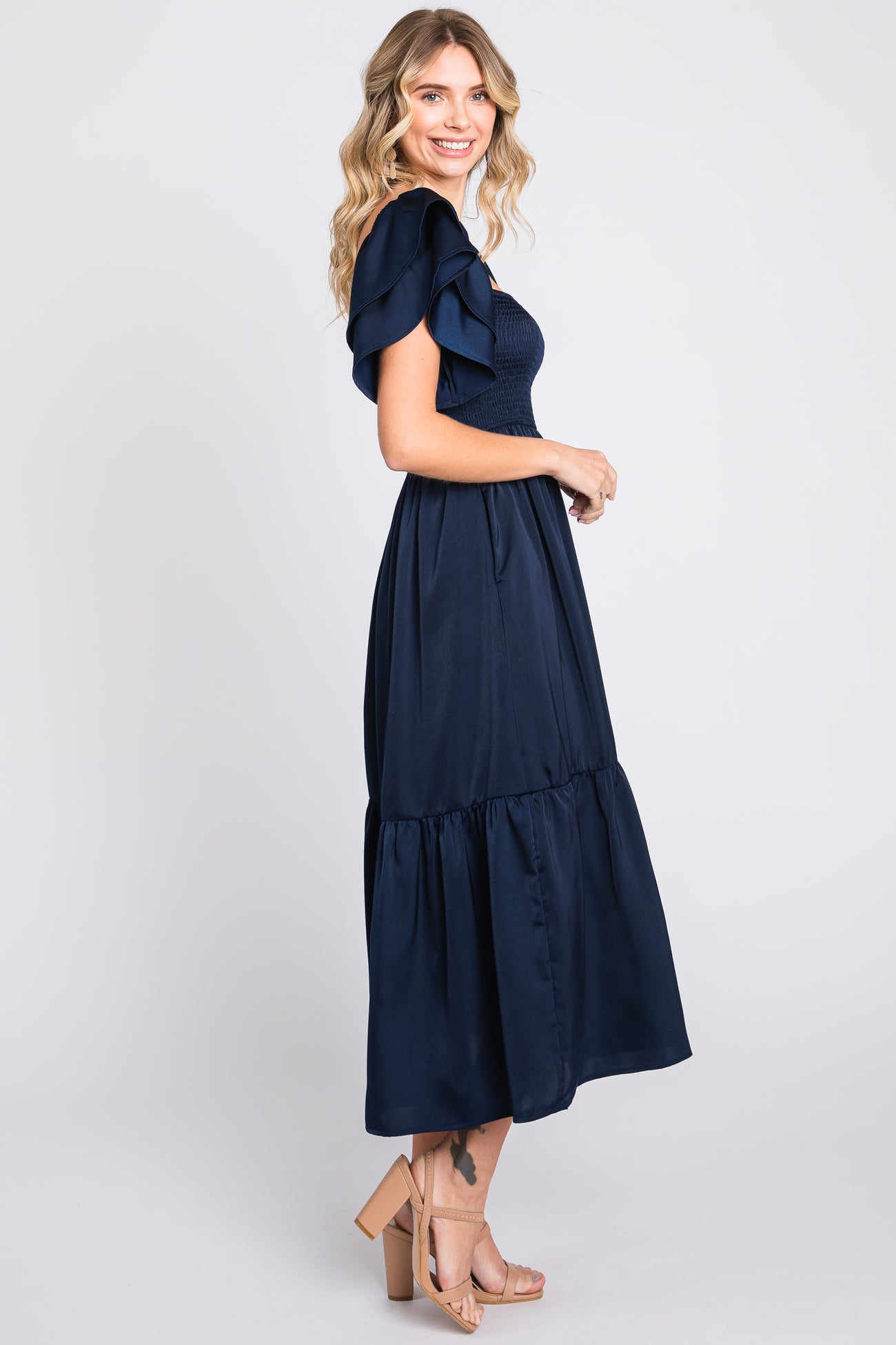 woman wearing a navy blue maxi dress with ruffled sleeves and a tiered hemline