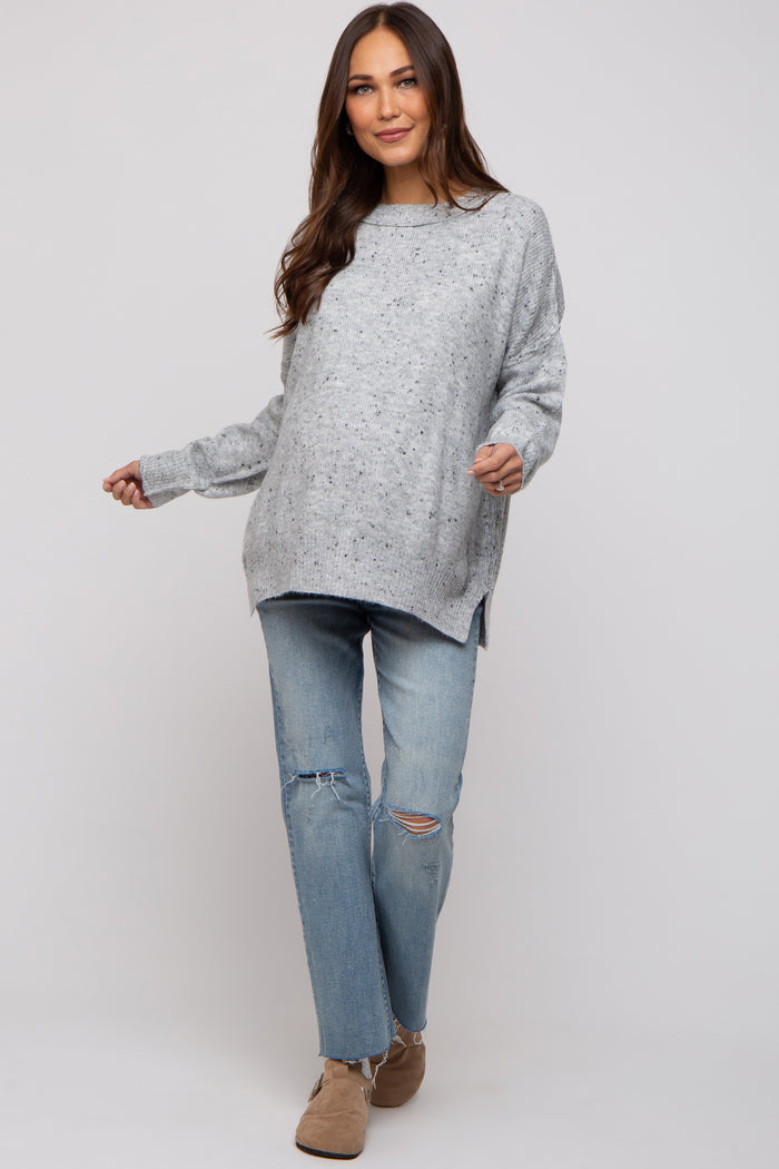 woman wearing a gray oversized maternity sweater with a loose fit and distressed jeans, featuring a relaxed style
