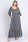 woman wearing a long floral maxi dress with puff sleeves and a square neckline, featuring side pockets