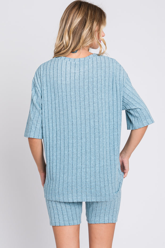 woman wearing a light blue short sleeve ribbed top and matching shorts, viewed from the back