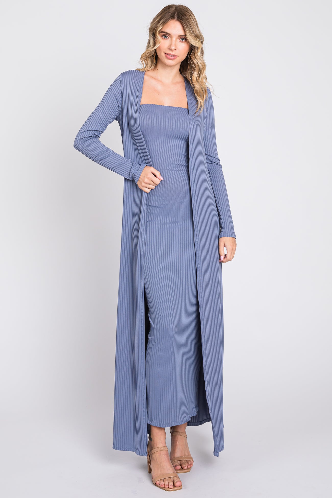 woman wearing a light blue ribbed maxi dress with long cardigan and strappy heels