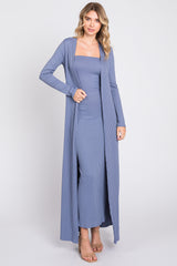 woman wearing a light blue ribbed maxi dress with long cardigan and strappy heels